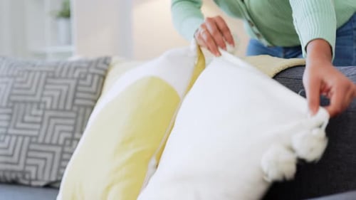 Closeup of interior designer using sofa and couch cushions or pillows to stage real estate house