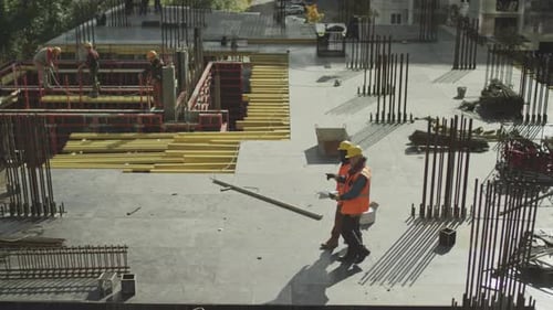 Construction Workers Inspecting Blueprints on Building Site