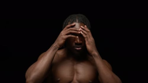 Retrato de estudio de un hombre negro sin camisa sonriendo a la cámara