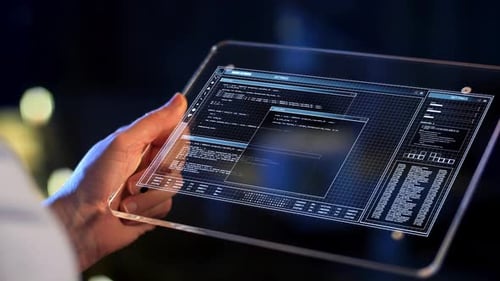 Hält ein transparentes Tablet mit futuristischen Codierungs- und Datenströmen in der Hand
