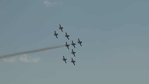 Snow bird planes fling by in formation.