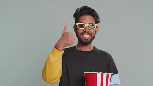 Young Adult Enjoys Popcorn and 3D Movie Experience