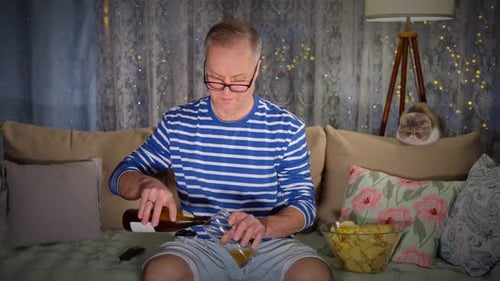 Man Relaxes on Couch Watching TV With Cat