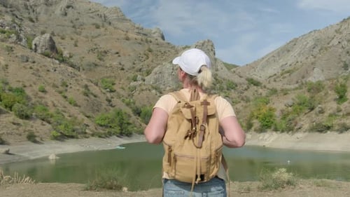 Woman with Backpack Enjoys Scenic Mountain View