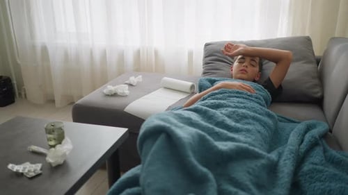 Teen Boy Lying Down with Cold Symptoms