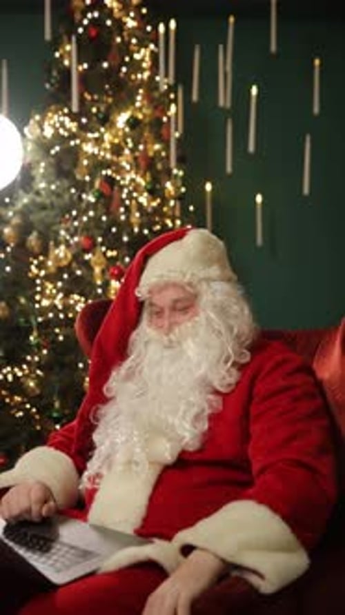 Santa Claus with Tablet Near Decorated Christmas Tree Vertical Video