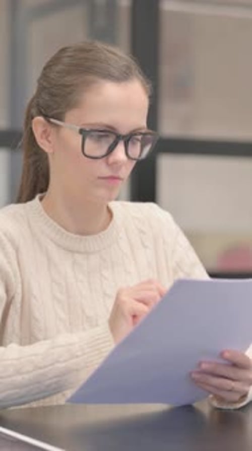 Young Woman Reading Documents at Work