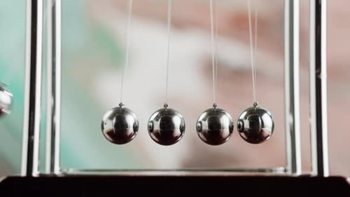 Newtons Cradle Demonstrates Physics and Momentum in Motion