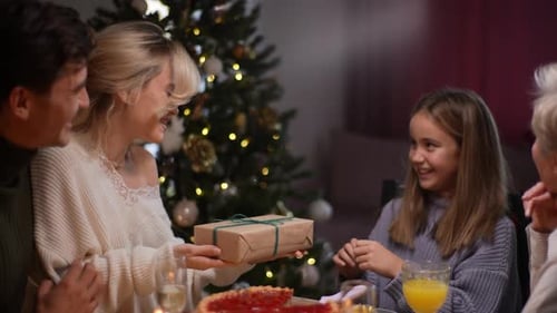 Family Exchanges Gifts by Christmas Tree