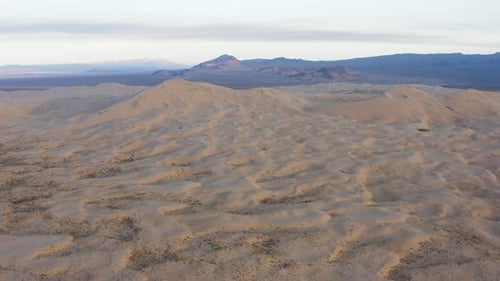 Vast desert sand dunes landscape at dusk seeing from above by drone