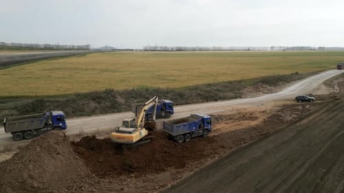 Excavator Loading Soil into Truck on Rural Site