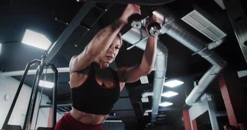 Muscular Woman Bodybuilder is Training in the Gym