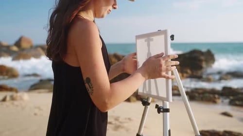 Artist Sets Up Easel Prepares to Paint on Serene Beach Waves Crash Against Rocks Creative Process