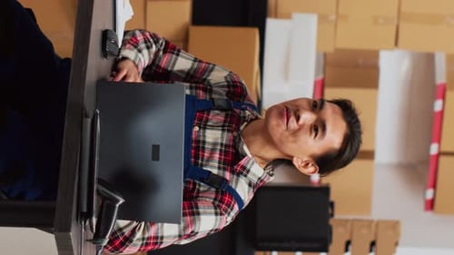 Adult Talking at Table With Boxes and Laptop