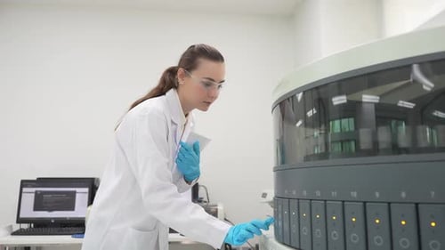 Woman Scientist Works in Lab with Machine