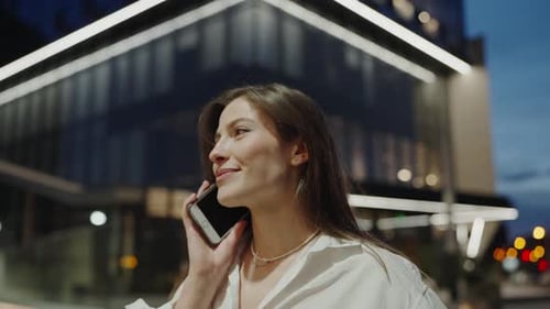 Young Woman Talking By Smartphone While Standing Near Business Center in City