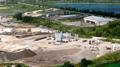 Drone Footage Showcasing a Large Construction Materials Factory with Storage Silos Machinery and
