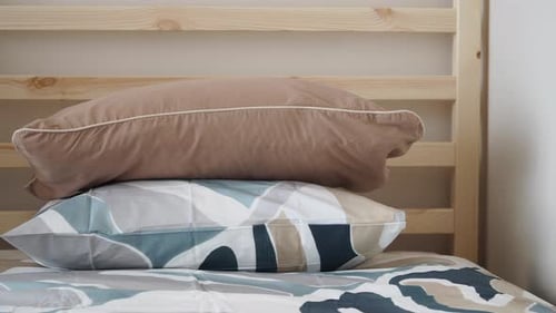 Stacked pillows on a tidy bed in bedroom