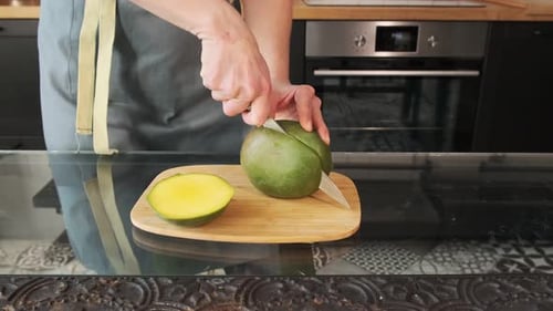 Close-up of a mango. The girl cuts the mango. Healthy food and diet