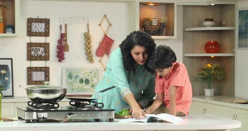 Woman Cooking with Boy at Kitchen Counter