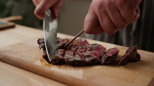 Slicing Freshly Grilled Tender Steak on Cutting Board
