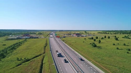 Aerial of Highway Through Green Meadows with Traffic on It on a Bright Sunny Day