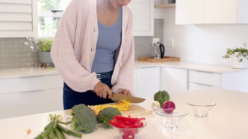 Indian woman chopping vegetables in modern kitchen, preparing healthy meal