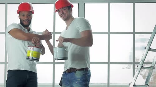 Construction Workers Handshake Indoors near Window