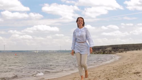 People and Leisure Concept - Happy Smiling Woman Walking Along Summer Beach Adult