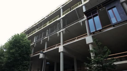 Un edificio moderno de concreto de varios pisos en construcción, que muestra estructuras expuestas, columnas,