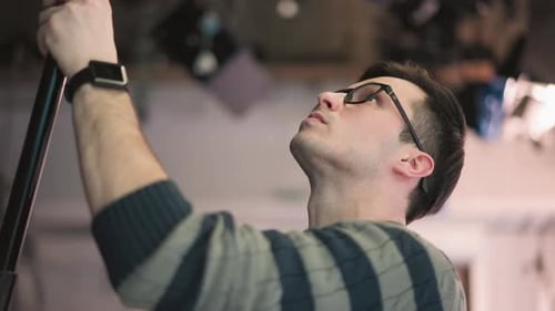 Closeup of Man Adjusting Boom Microphone During Sound Recording in Video Production Studio