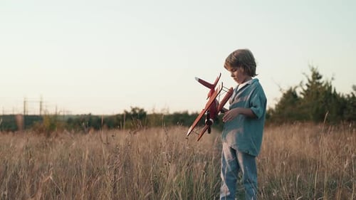 Un curioso niño preescolar de 5 años juega a manualidades con un avión de madera de estilo retro