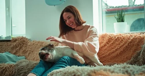 Woman Petted Bulldog Lying on Her Lap