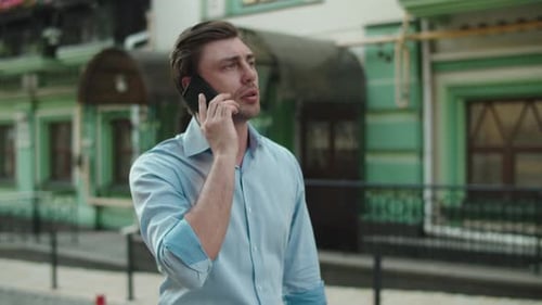 Young Business Man Walking with Mobile Phone at Street. Smiling Businessman Call