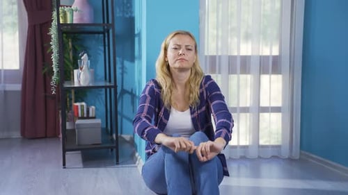 Distraught Woman Sitting on Floor at Home