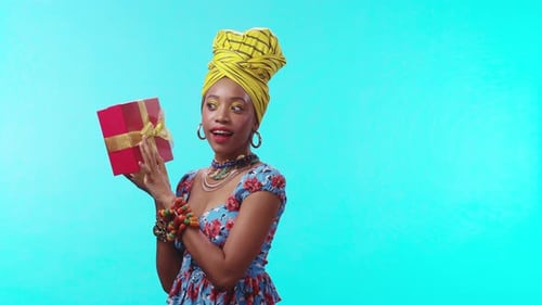 A Celebratory Woman Dressed in Colorful Attire Holding a Gift Radiating Joy and Cheerfulness