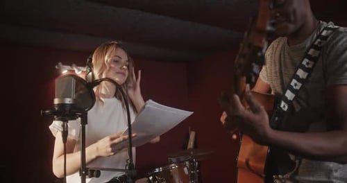 Singer and Guitarist Recording Music in Studio