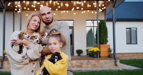 Happy Family With Beagle Puppies Outside Their Home