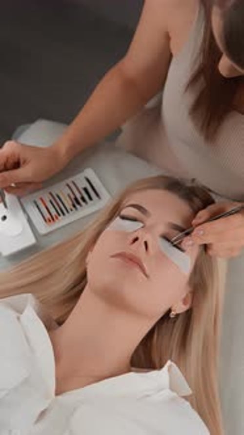 Procedimento profissional de extensão de cílios em um salão de beleza moderno com um técnico qualificado