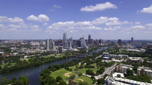 Austin skyline and the Colorado river in sunny Texas, USA - tracking, aerial view
