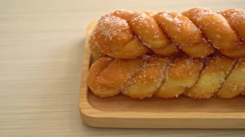 sugar doughnut in spiral shape on wooden plate