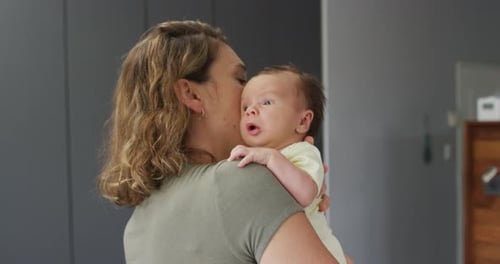 Video of caucasian mother holding and hugging newborn baby