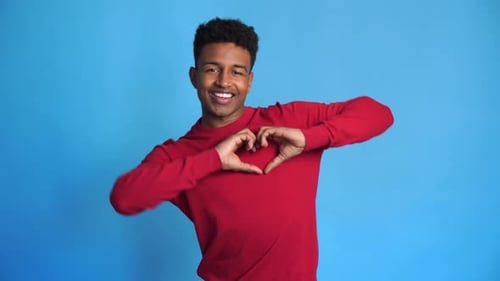 Young Man Making Heart Shape Gesture, Smiling