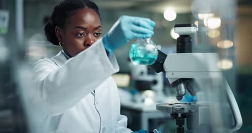 Young Scientist Analyzing Solution in Bright Lab