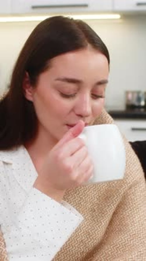 Woman in Pajamas Enjoying Warm Drink Indoors