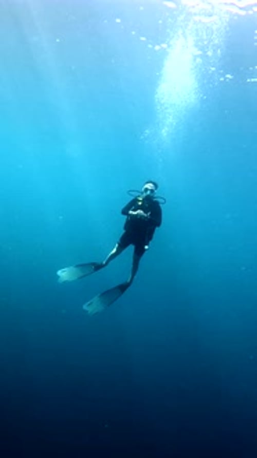Scuba Diver Floating Peacefully in Deep Blue Ocean Water
