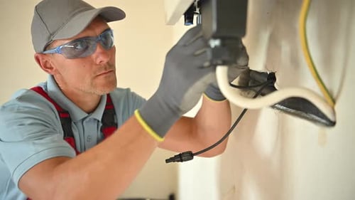 Professional technician performing solar electrical installation in residential environment