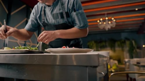 Close-up chef preparing bruschetta tongs beef avocado and tomatoes in professional kitchen
