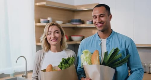 Happy Couple with Groceries in Modern Kitchen