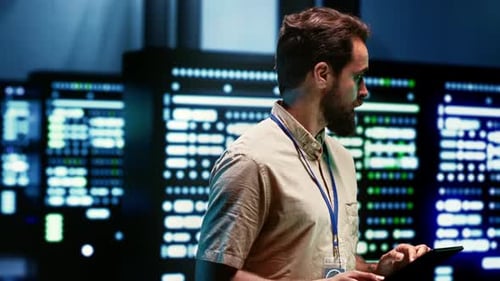 Man Working with Servers and Tablet in Dark Room